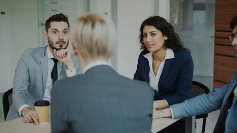 Участники деловой встречи обсуждают работу за столом